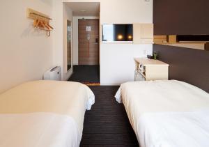 a hotel room with two beds and a bathroom at Super Hotel JR Nara Ekimae Sanjo Dori in Nara