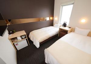 a hotel room with two beds and a window at Super Hotel JR Nara Ekimae Sanjo Dori in Nara