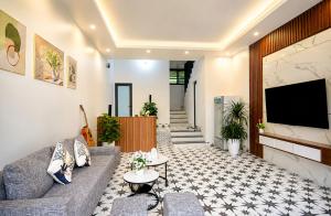 a living room with a couch and a flat screen tv at Sweet Apartment Sa Pa in Sapa