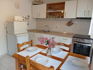 a kitchen with a table with plates and flowers on it at Walnuthouse in Dhíkella