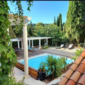 a swimming pool in a garden with a pergola at Villa Jalna bis in Béziers
