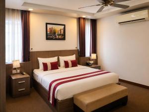 a bedroom with a large bed with red pillows at Norodom Clover Hotel in Phnom Penh +18 photos