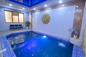 a swimming pool in a house with a blue ceiling at Suleyman hotel in Bukhara