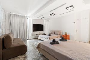 a living room with two beds and a couch at Villa Marbella Eilat in Eilat