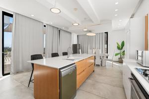 a kitchen with a sink and a counter with chairs at Villa Marbella Eilat in Eilat