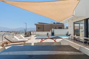 a patio with a table and chairs on top of a building at Villa Marbella Eilat in Eilat