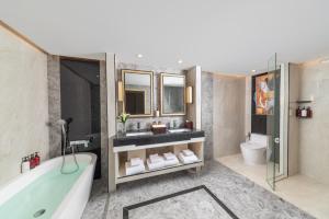 a bathroom with a tub and two sinks and a toilet at Samala Suites Bangkok Sukhumvit 19 by Kingston Hotels in Bangkok +76 photos