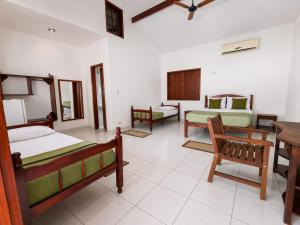 a bedroom with two beds and a table and chairs at Pousada Brisa leve Paraty in Paraty