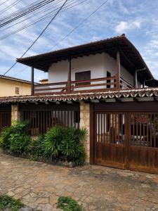 a house with a wooden gate in front of it at Pousada Brisa leve Paraty in Paraty