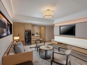 a living room with a couch and a tv at Samala Suites Bangkok Sukhumvit 19 by Kingston Hotels in Bangkok