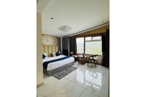 a bedroom with a bed and a table in it at The Moonsoon Inn in Mussoorie