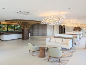 a lobby with white furniture and a chandelier at oneTree Plaza Hotel Cebu in Cebu City