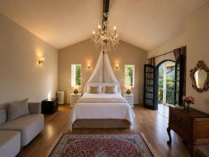 a large bedroom with a bed and a chandelier at Pousada Casa Florinda in Teresópolis