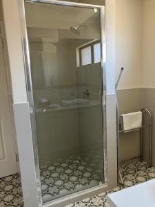 a glass shower in a bathroom with a sink at Seaview on Kent in Rockingham