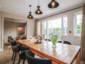 a dining room with a large wooden table and chairs at Ivet Lowe in Matlock