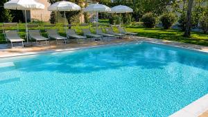 a swimming pool with chairs and umbrellas at Ca' Tessera Venice Airport in Tessera