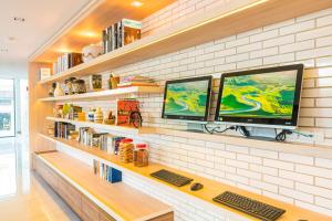 two computer monitors sitting on a shelf in a room at Koon Hotel Sukhumvit in Bangna