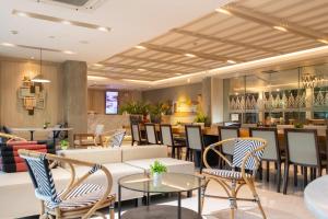 a restaurant with chairs and tables and a bar at Koon Hotel Sukhumvit in Bangna