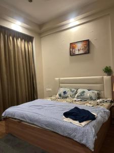 a bedroom with a bed with a blue blanket at Luxura stays in Greater Noida