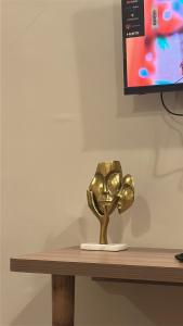 a gold trophy sitting on a wooden table at Luxura stays in Greater Noida