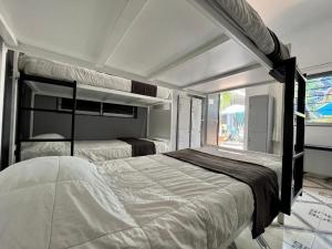 a bedroom with two beds and a large window at WHOST Hotel y Hostal in Mexico City