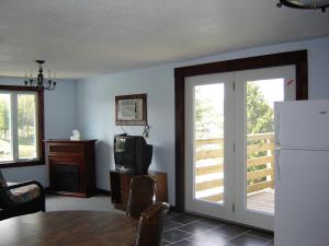 ein Esszimmer mit einem Tisch, einem TV und einem Kühlschrank in der Unterkunft Sauble River Marina and Lodge Resort in Sauble Beach