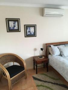 a bedroom with a bed and a chair and a table at Seaview on Kent in Rockingham