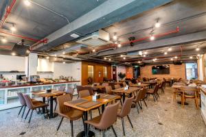 a restaurant with wooden tables and chairs and a counter at Violet hotel&spa in Nha Trang