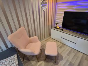 a living room with two chairs and a flat screen tv at klein aber fein in Freudenthal