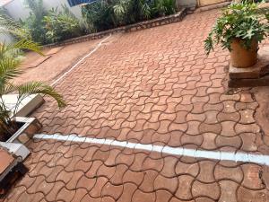 a brick driveway with plants on it at Zone hotel and guest house in Bugembe +8 photos