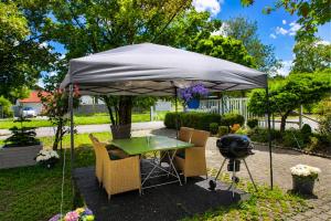 a table and chairs under an umbrella with a grill at Hotel Garni in Burghausen