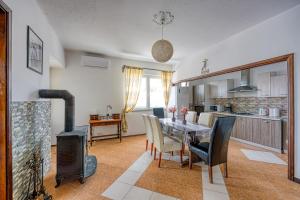 a kitchen and dining room with a table and a stove at Pool & Garden Apartment Bakija - Happy Rentals in Pakoštane