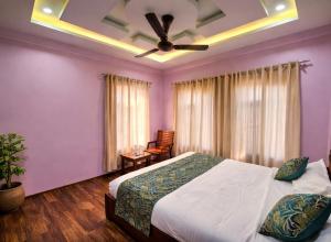 a bedroom with a bed and a ceiling fan at Hotel Riverwood Kokernag in Wāngom +4 photos