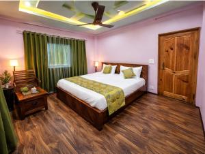 a bedroom with a large bed and a wooden floor at Hotel Riverwood Kokernag in Wāngom