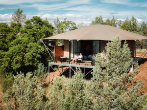 a man sitting in a tent in front of a house at Wilderluxe Lake Keepit in Keepit