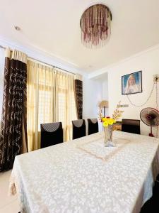 a dining room with a table with a vase of flowers on it at Shek Residence in Colombo