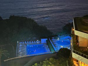a swimming pool next to the ocean at night at Dogashima New Ginsui in Nishiizu +64 photos