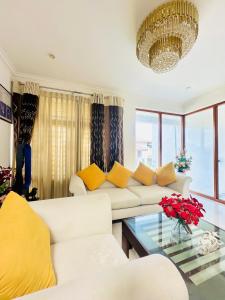 a living room with white furniture and a chandelier at Shek Residence in Colombo