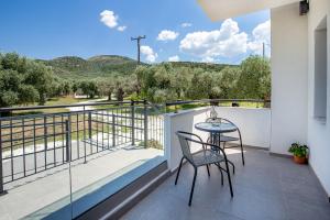 a balcony with a table and chairs and a view at O-live in Prinos