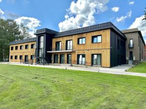 a building with a grass field in front of it at GU DESIGN apartments in Saldus