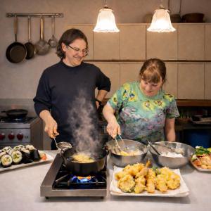 a man and a woman preparing food in a kitchen at toyoukenomori in Mitsugarasuchō