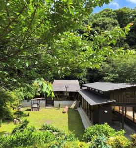 a building in a yard with a dog in the grass at toyoukenomori in Mitsugarasuchō