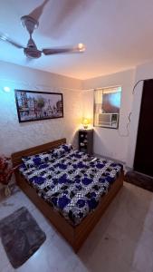 a bed in a bedroom with a ceiling fan at Savera hommes in Ghaziabad