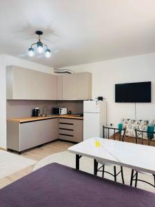 a kitchen with a table and a white refrigerator at Balor152 in Koshkolʼ