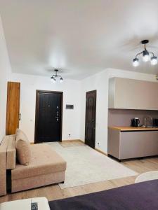 a living room with a couch and a kitchen at Balor152 in Koshkolʼ