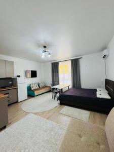 a bedroom with a bed and a living room with a table at Balor152 in Koshkolʼ
