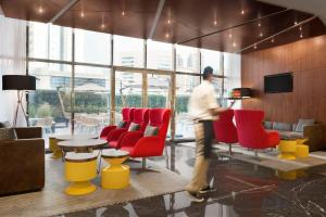 a man walking through a room with chairs and tables at TRYP by Wyndham Dubai in Dubai +42 photos
