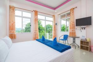 a bedroom with a large bed with blue pillows on it at Phuyafahsai The Resort Khao Kho in Khao Kho