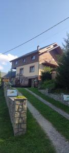 a house with a stone wall in front of it at Буркут in Yaremche