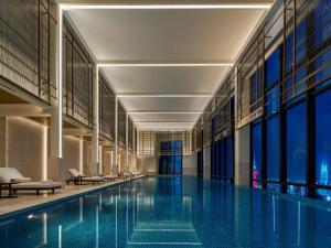 a swimming pool in a building with windows at Park Hyatt Kuala Lumpur in Kuala Lumpur